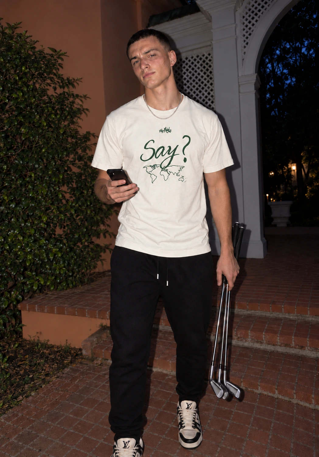 Say? tee styled with black trousers and golf irons